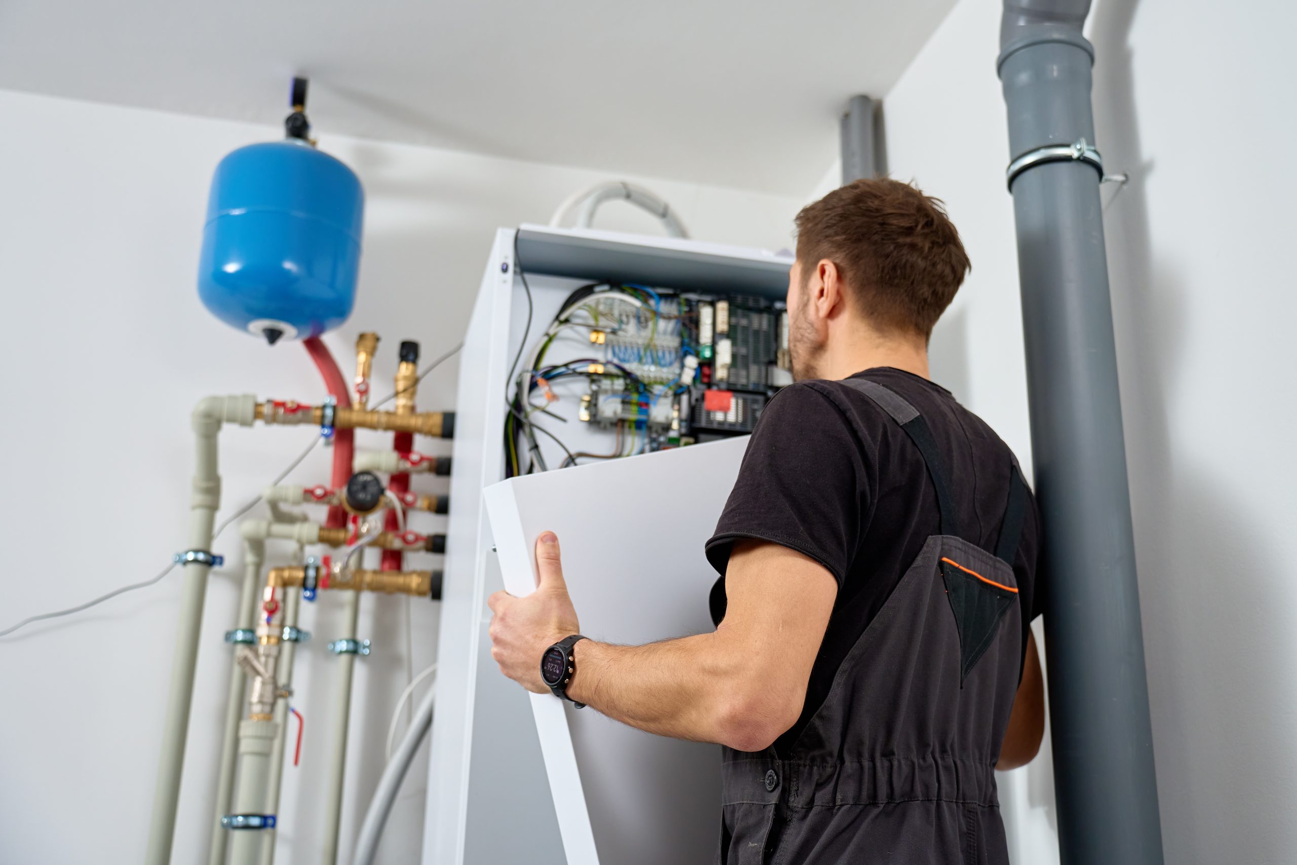 Technician open control unit to inspecting heat pump system in house